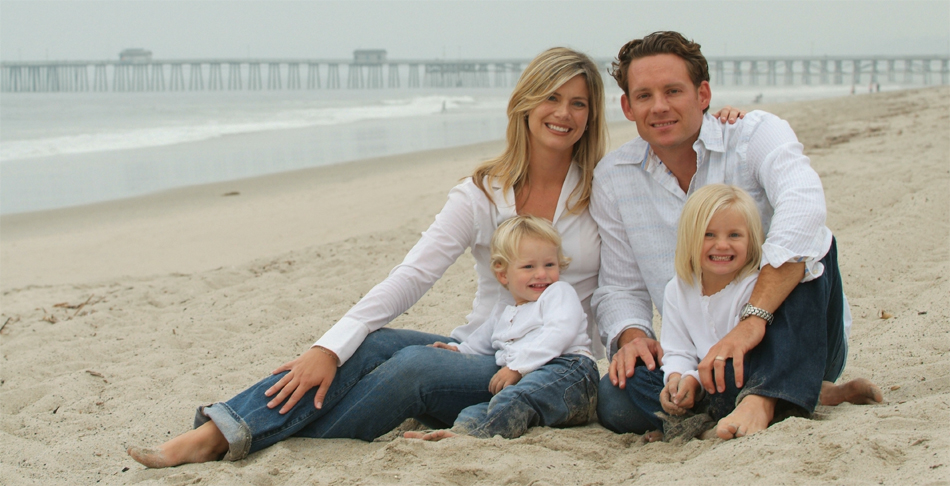 Mother, father and two children sitting on the beach